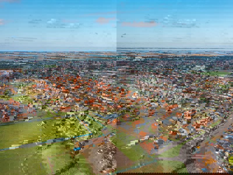 A birds eye view of a thriving town filled with red brick homes